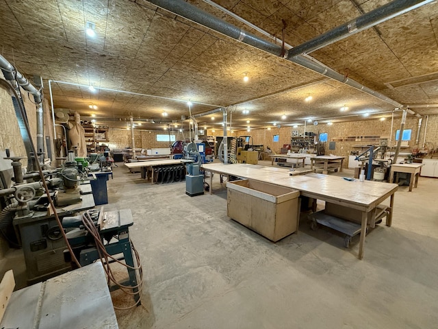 miscellaneous room with concrete flooring and a workshop area