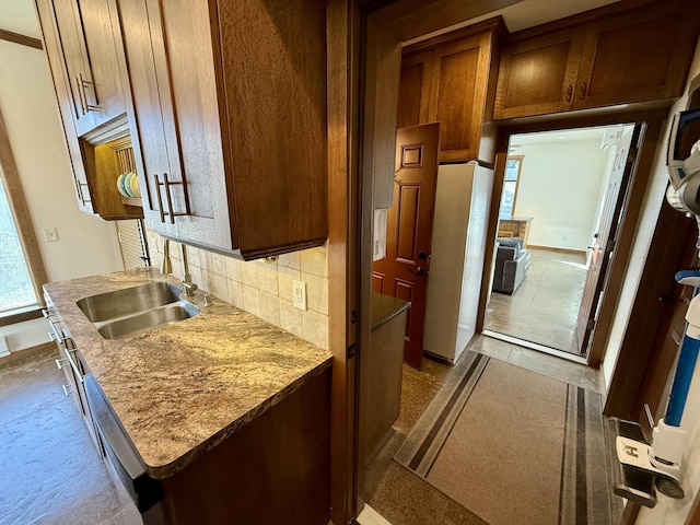 kitchen featuring sink, decorative backsplash, light stone countertops, and white fridge