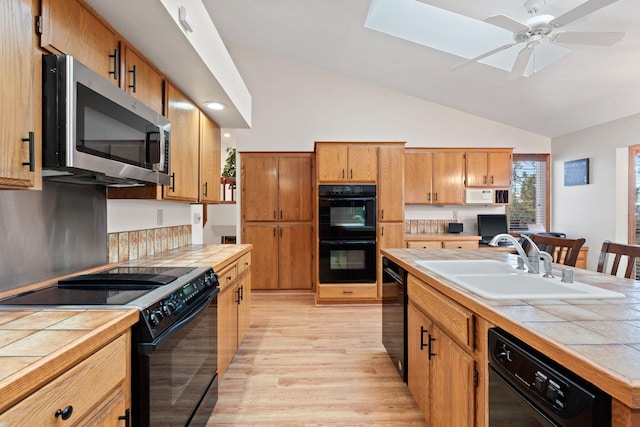 4203 S Suncrest Ln, Spokane Valley, WA 99037 - kitchen featuring black appliances, tile countertops, light wood-style flooring, and vaulted ceiling