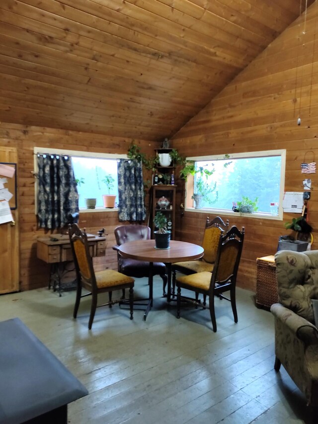 dining area with wood ceiling, vaulted ceiling, wood walls, and hardwood / wood-style flooring