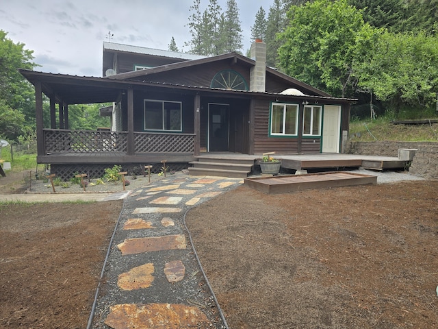 1612 Rickey Canyon Rd, Kettle Falls, WA 99141 - view of front of property featuring a chimney, a metal roof, and covered porch