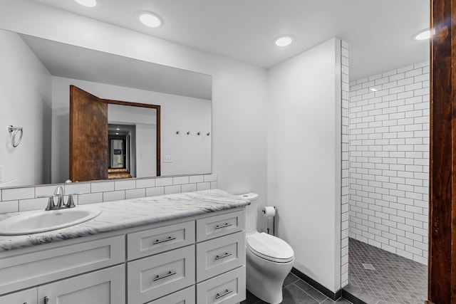 bathroom featuring a shower, tile patterned floors, vanity, and toilet