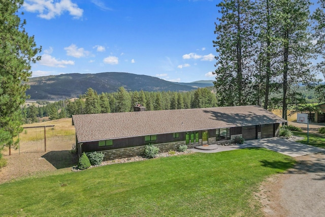 view of front of house featuring a mountain view, a garage, and a front lawn