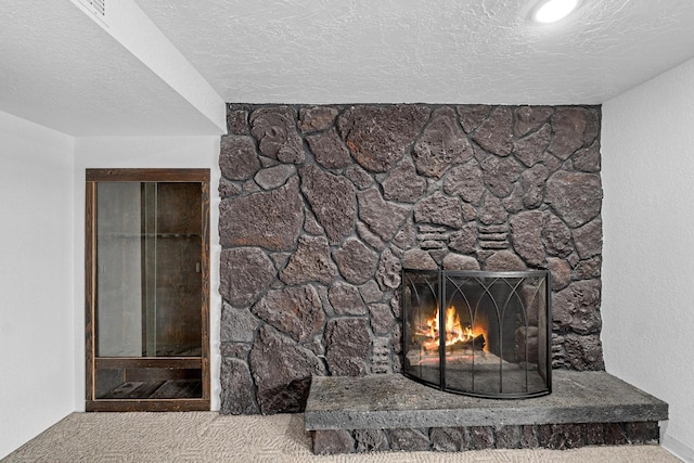 details featuring carpet, a textured ceiling, and a stone fireplace