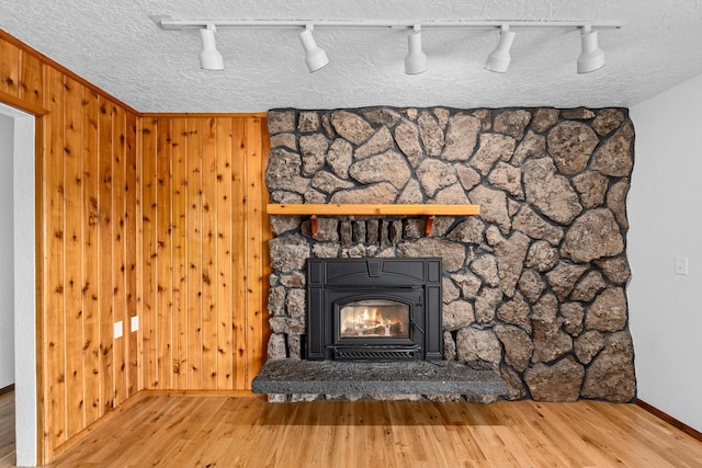 details featuring wood walls, rail lighting, a textured ceiling, and wood-type flooring