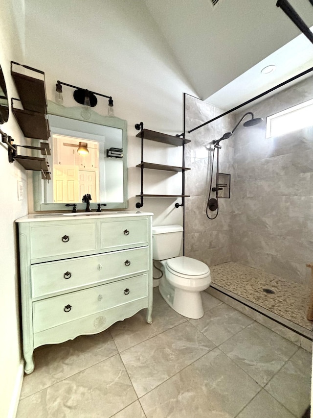 full bath with lofted ceiling, toilet, a tile shower, and vanity