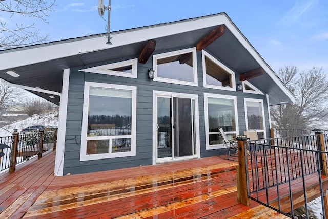 snow covered rear of property featuring a wooden deck