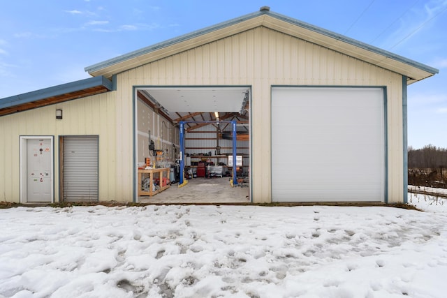 snow covered garage featuring a detached garage