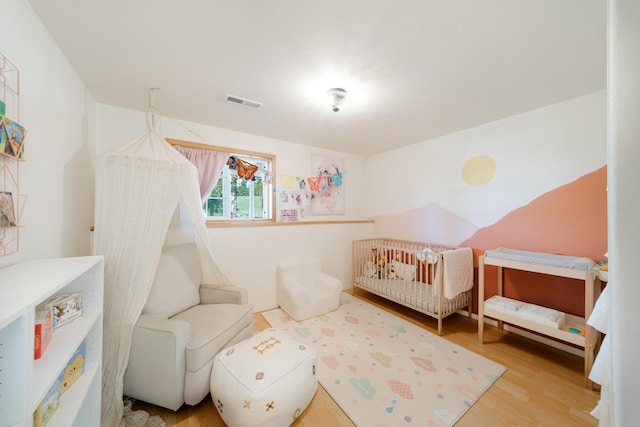 bedroom featuring visible vents and wood finished floors