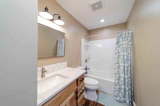 bathroom featuring shower / bath combo, visible vents, toilet, wood finished floors, and vanity