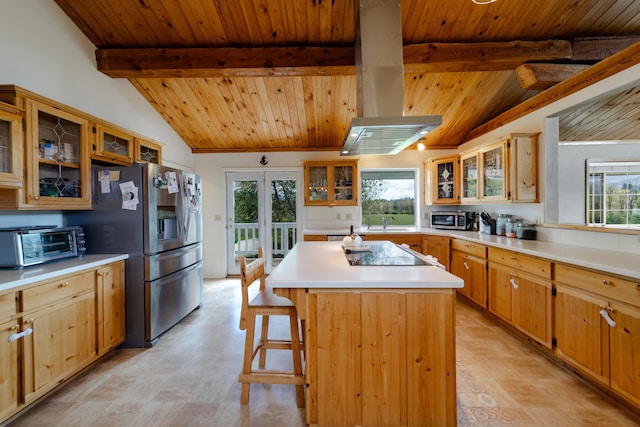 kitchen with a kitchen island, glass insert cabinets, a kitchen breakfast bar, stainless steel appliances, and light countertops