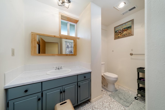 bathroom featuring visible vents, toilet, vanity, baseboards, and tile patterned floors