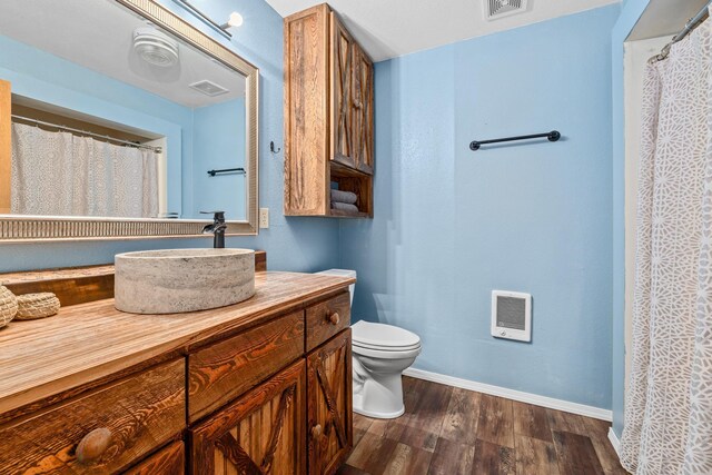 full bathroom featuring toilet, wood finished floors, visible vents, vanity, and baseboards