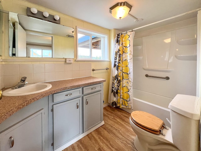 full bathroom with toilet, hardwood / wood-style floors, shower / tub combo, tasteful backsplash, and vanity