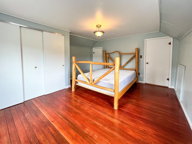 unfurnished bedroom with hardwood / wood-style floors, a closet, and vaulted ceiling