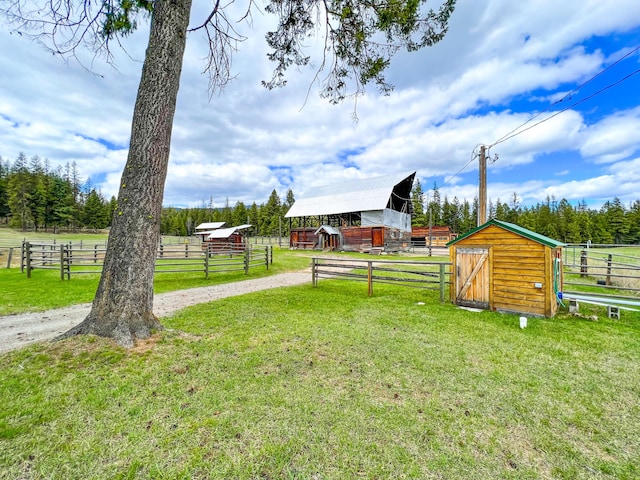 view of yard featuring an outdoor structure and a rural view