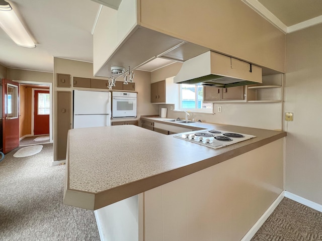 kitchen featuring sink, white appliances, kitchen peninsula, and light carpet