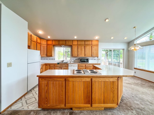 kitchen featuring white appliances, decorative backsplash, sink, hanging light fixtures, and a large island