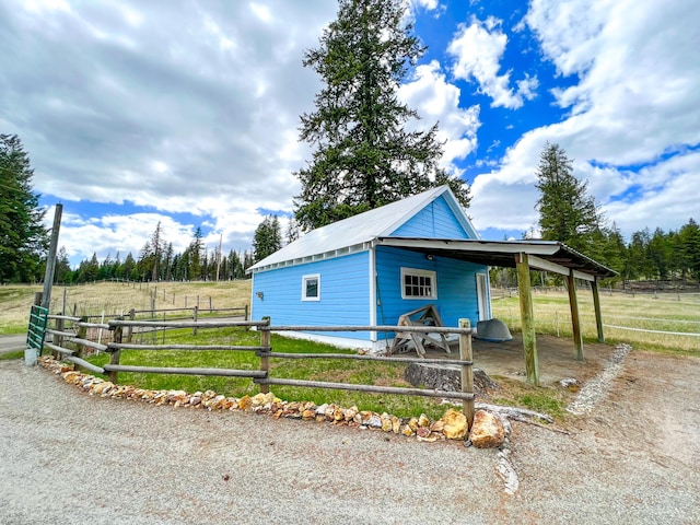 view of front of property with an outbuilding and a rural view