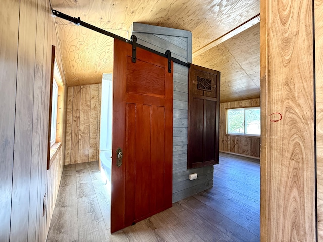 3305 Bradeen Rd, Rice, WA 99167 - corridor with wood walls, wood-type flooring, a barn door, and vaulted ceiling