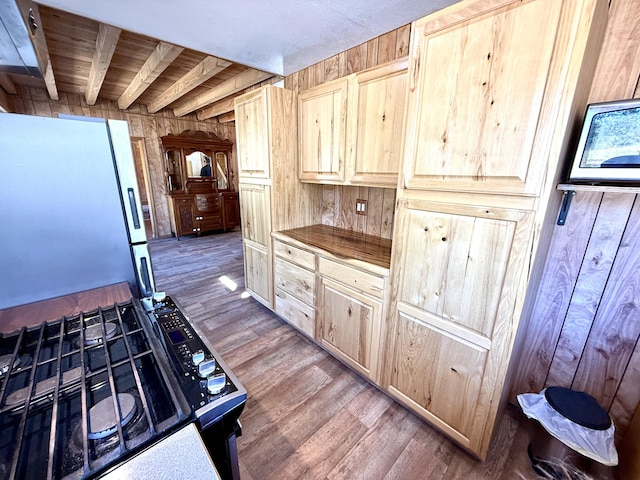3305 Bradeen Rd, Rice, WA 99167 - kitchen featuring wood walls, wood finished floors, light brown cabinets, freestanding refrigerator, and range with gas cooktop