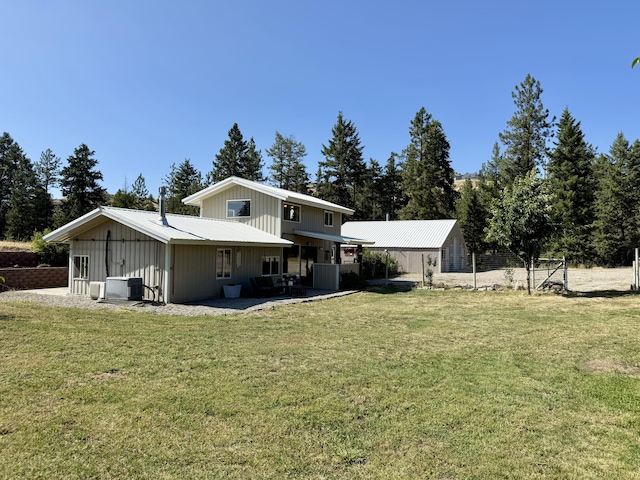 3305 Bradeen Rd, Rice, WA 99167 - back of property with board and batten siding, a lawn, and a patio area