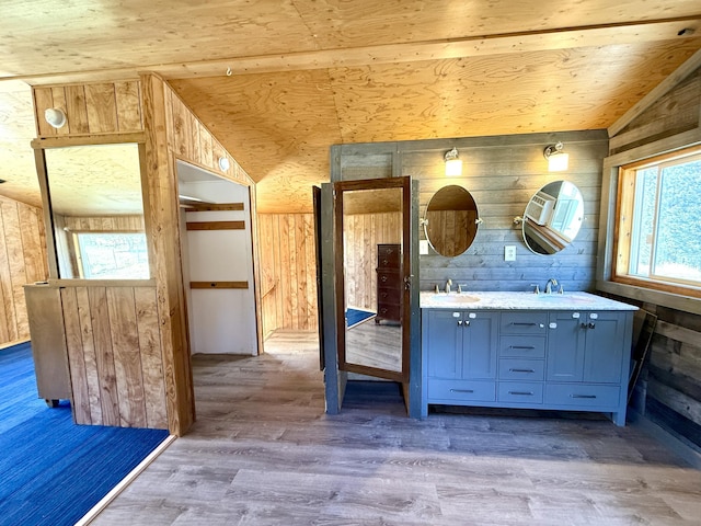 3305 Bradeen Rd, Rice, WA 99167 - bathroom featuring wood walls, double vanity, healthy amount of natural light, lofted ceiling, and wood finished floors
