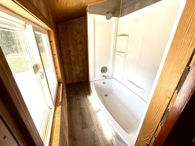 3305 Bradeen Rd, Rice, WA 99167 - bathroom featuring hardwood / wood-style flooring, wood walls, and bathing tub / shower combination