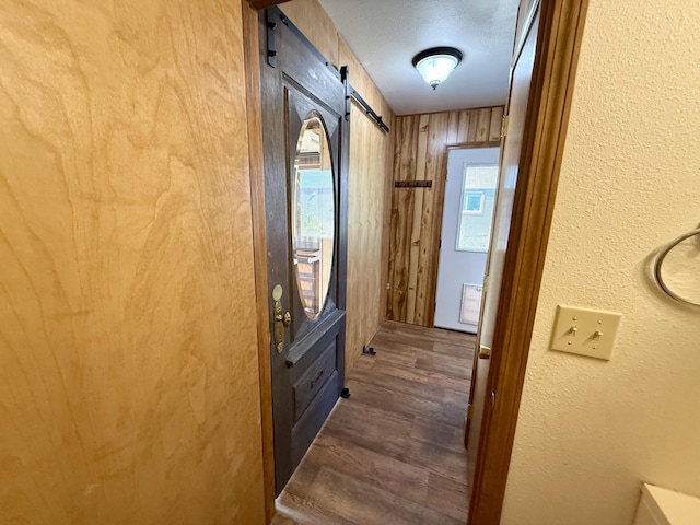 3305 Bradeen Rd, Rice, WA 99167 - doorway to outside with a barn door, dark wood finished floors, a textured wall, and a textured ceiling