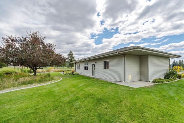 back of house with a yard and a patio