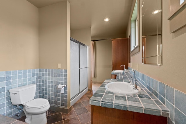 bathroom featuring tile walls, an enclosed shower, vanity, tile patterned floors, and toilet