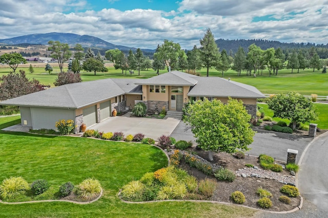 prairie-style house with a garage, a mountain view, and a front lawn