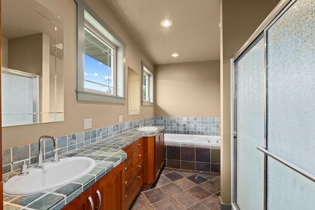 bathroom featuring tile patterned flooring, vanity, and shower with separate bathtub