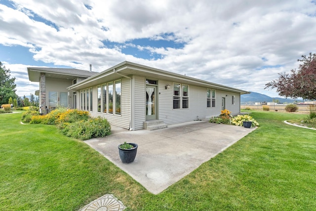 back of property featuring a patio and a lawn