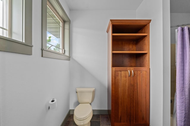 bathroom featuring tile patterned flooring, a shower with shower curtain, and toilet