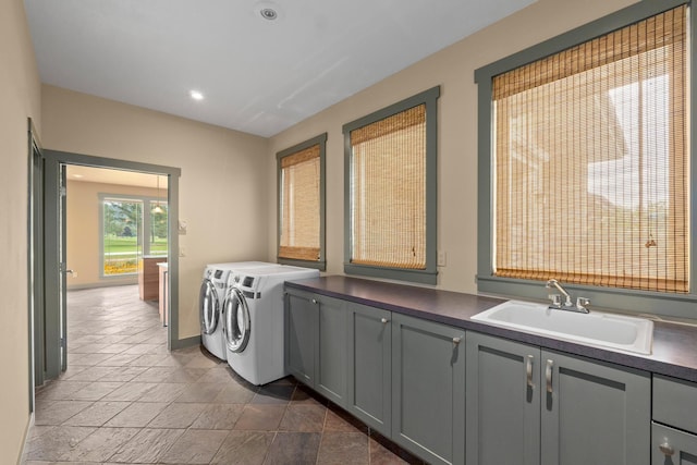 laundry area with sink, washing machine and dryer, and cabinets