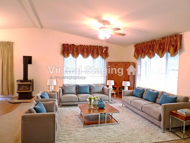 carpeted living room featuring ceiling fan, a wood stove, and vaulted ceiling with beams