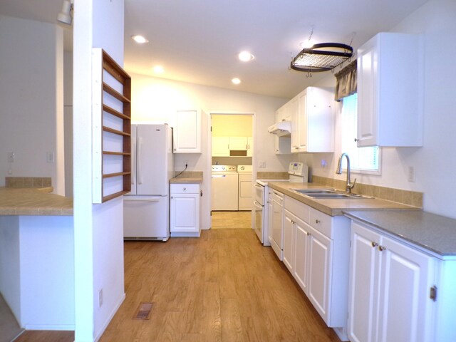 kitchen featuring sink, light wood-type flooring, white cabinetry, white appliances, and washer and clothes dryer