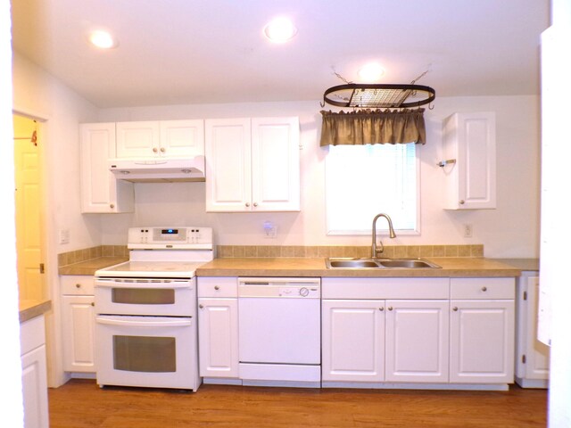 kitchen with white cabinetry, sink, white appliances, and light hardwood / wood-style flooring