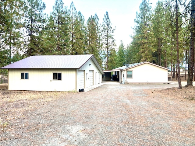 17 Crestview Dr, Kettle Falls, WA 99141 - view of property exterior featuring a detached garage, an outdoor structure, a metal roof, and driveway