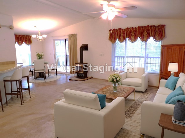 living room featuring ceiling fan with notable chandelier, light colored carpet, and lofted ceiling