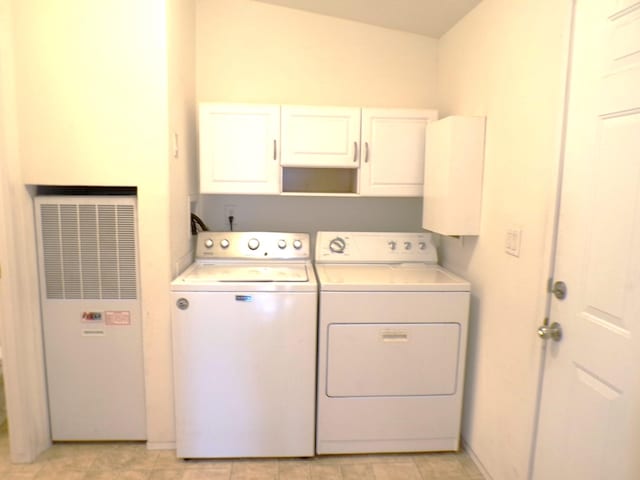 washroom featuring cabinets and washer and clothes dryer