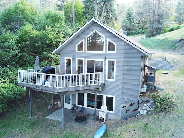 2122 Northport Flat Creek Rd, Kettle Falls, WA 99141 - back of property with a deck, a forest view, central air condition unit, and a patio area