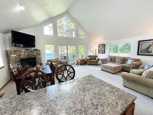 2122 Northport Flat Creek Rd, Kettle Falls, WA 99141 - carpeted living room with plenty of natural light, a stone fireplace, and high vaulted ceiling