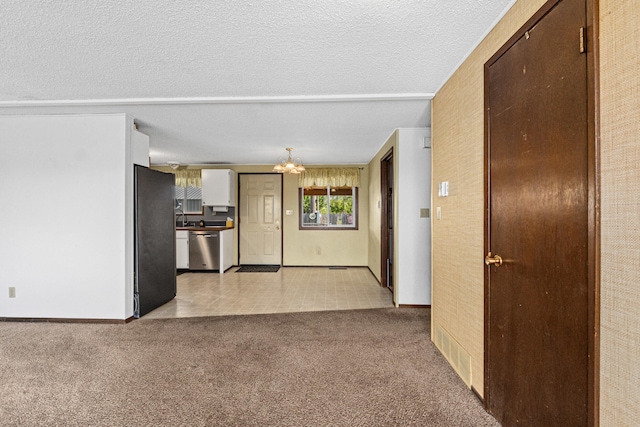 505 W Court Ave, Chewelah, WA 99109 - kitchen with dishwasher, a chandelier, freestanding refrigerator, light colored carpet, and a textured ceiling