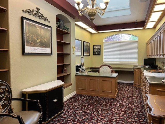 office with built in shelves, a chandelier, and built in desk