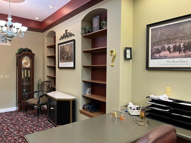 office area with dark carpet, built in features, and a chandelier