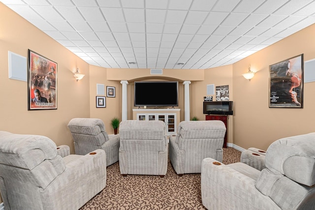 carpeted cinema room with decorative columns