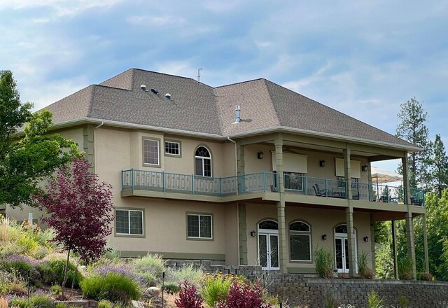 back of house featuring a balcony and french doors