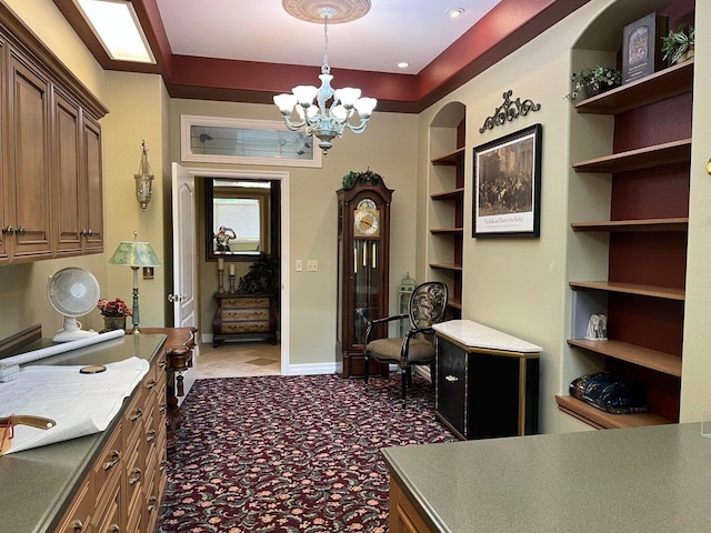 home office with built in features and a notable chandelier